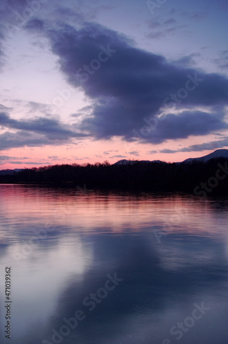 淡い色合いの夜明けの空を湖面に反射する湖。