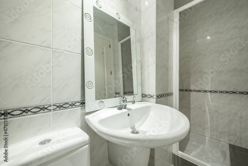 Conventional toilet with white sink  shower and mirror