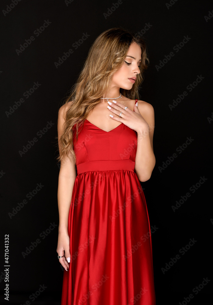 Elegant poised young woman modelling a stylish red dress Elegant poised young woman modelling a stylish red dress