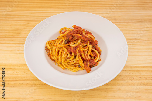 Bucatini all'amatriciana, is a traditional Italian pasta dish made with a famous sauce based on guanciale, pecorino cheese, tomato, usually onion