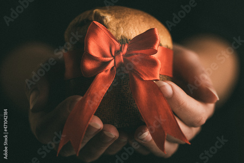 Hands Woman holding panettone wrapped as a christmas gift photo