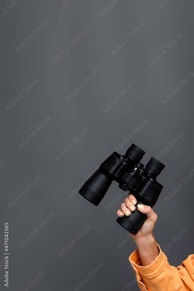 Cropped view of tourist holding binoculars isolated on grey