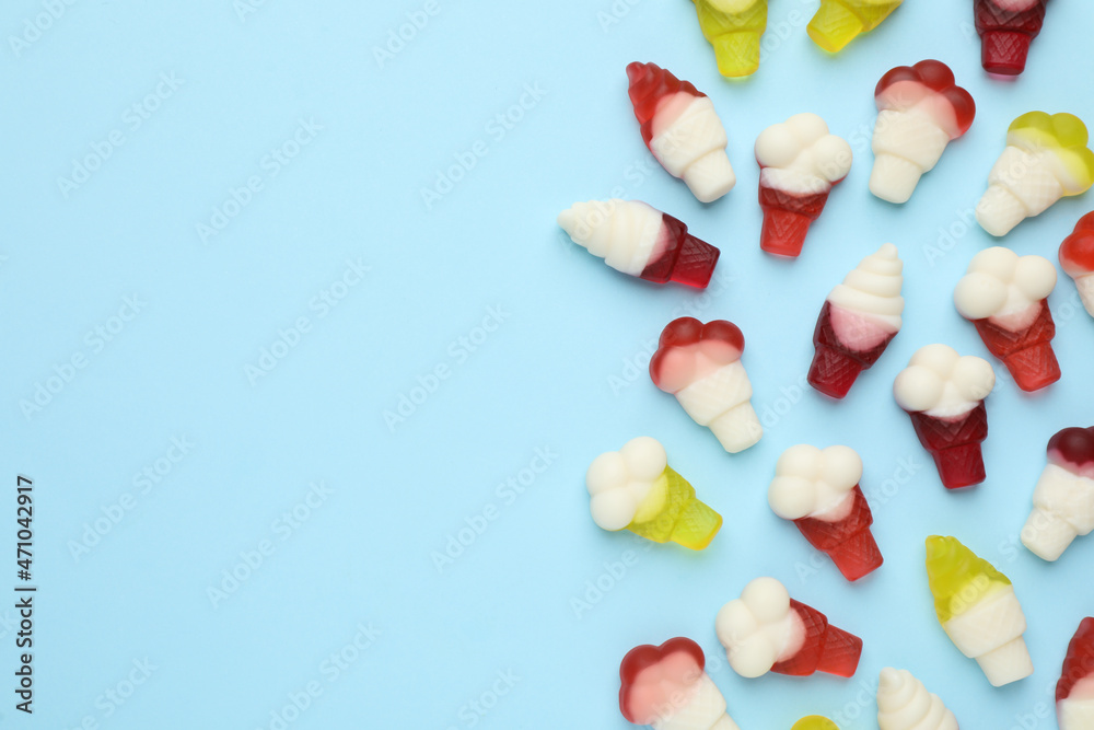 Tasty jelly candies in shape of ice cream on light blue background, flat lay. Space for text Tasty jelly candies in shape of ice cream on light blue background, flat lay. Space for text