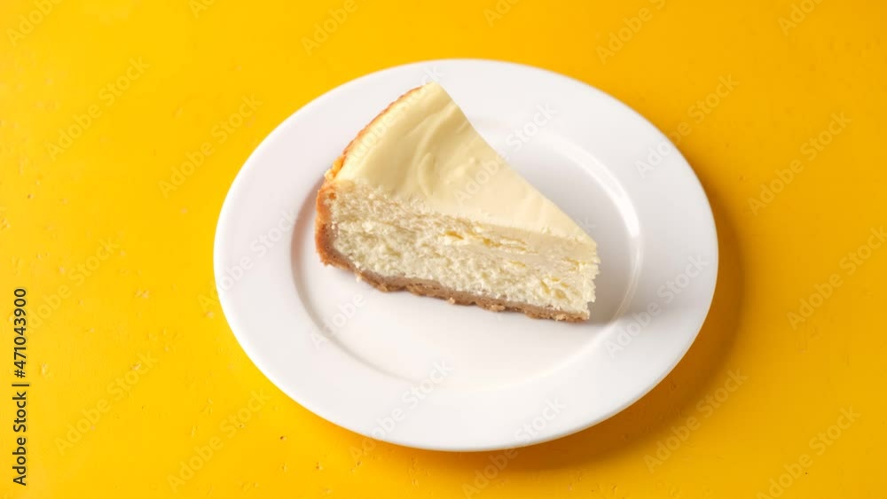 Serving slice of new york cheesecake yellow background. Delicious slice of classical cheesecake Serving slice of new york cheesecake yellow background. Delicious slice of classical cheesecake