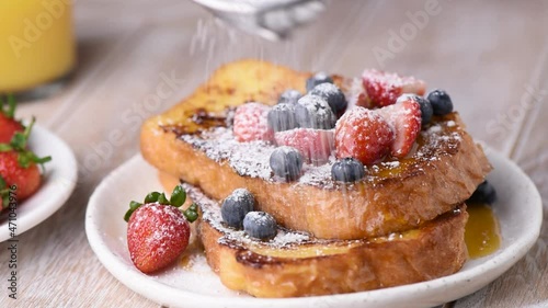 Serving sweet french toast with berries and powdered sugar, closeup view. Breakfast, lunch or dessert food