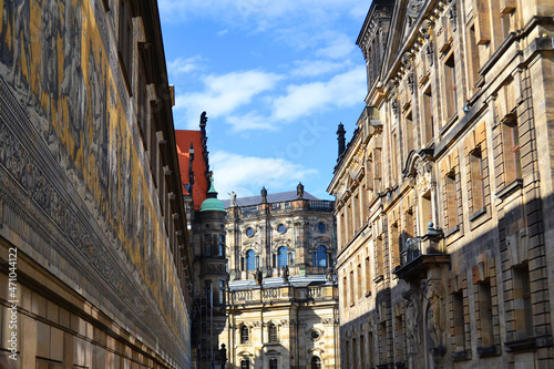 Augustus Street in Dresden, Saxony, Germany. Furstenzug giant mural decorates mosaic on the wall on the left and Dresden Cathedral, or the Cathedral of the Holy Trinity in the middle.