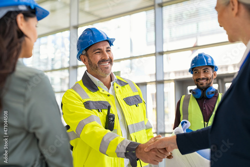 Mature architect and contractor shaking hands at construction site