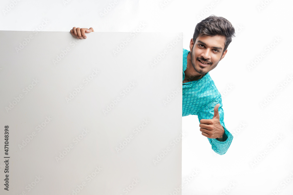 Indian man holding white board, promoting offers on festival season while wearing traditional cloths, standing over white background. Indian man holding white board, promoting offers on festival season while wearing traditional cloths, standing over white background.