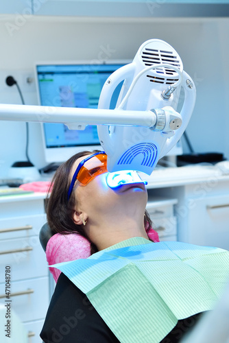 Teeth whitening procedure with ultraviolet light lamp.