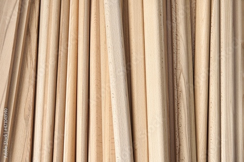Huge pile of wooden bars made of solid beechwood material lies in contemporary carpentry workshop as backgroung closeup upper view