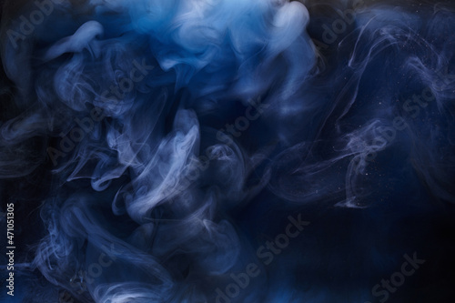 Blue smoke on black ink background, colorful fog, abstract swirling ocean sea, acrylic paint pigment underwater