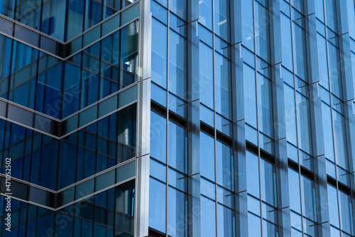 Modern glass architecture of an office building windows close up in blue colors 