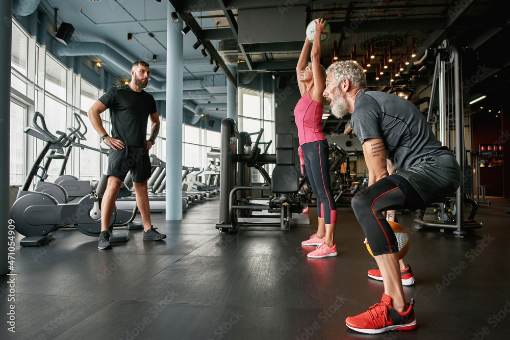 Fototapeta Crossfit ball fitness workout for mature couple