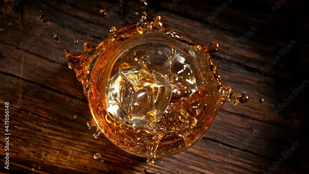 Super Slow Motion Shot of Ice Cube Falling into Whiskey at 1000fps. Super Slow Motion Shot of Ice Cube Falling into Whiskey at 1000fps.