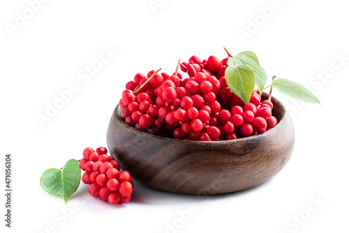 Schisandra chinensis berries in wooden bowl isolated on white photo