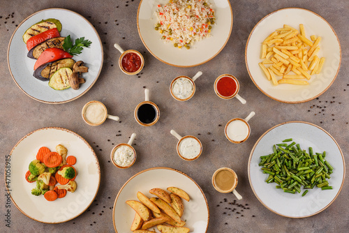 Assortment of side dishes and sauces on plates.