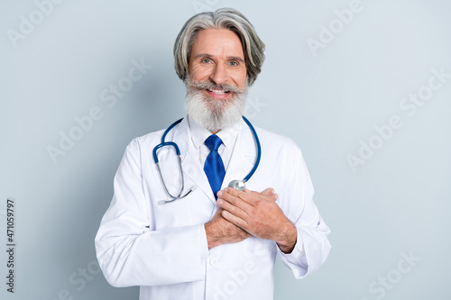 Photo of experienced doc man put hand heart hippocratic oath protect infarct old people patient isolated over grey color background photo
