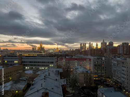 Moscow city center urban winter yellow orange sunset panorama view with skyscrapers, buildings, rooftops on a dramatic grey clouds sky background