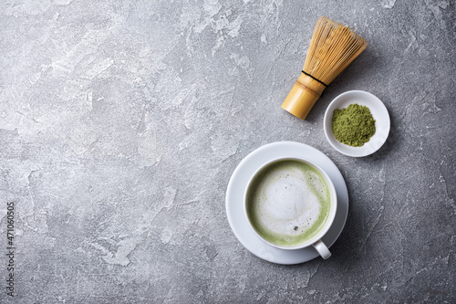 Organic green matcha latte in cup with bamboo whisk