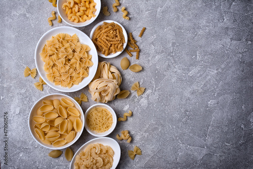 Mix of Italian raw pasta in white bowls