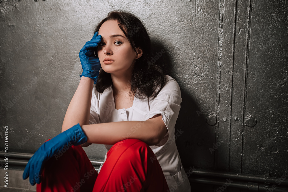 Obraz premium Nurse worker have headache migraine feel bad pain tired owerworked stressed touching temples. Female doctor dressed medical white gown blue sterile rubber gloves red pants, healthcare overwhelmed