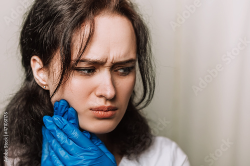 Nurse woman female worker have suffering terrible toothache migraine feel bad pain tired owerworked. Female doctor dressed medical white gown blue rubber gloves need to visit a dentist
 photo