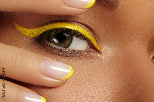 Obraz na plátně Close-up Female Eye with bright yellow Eyeliner Makeup