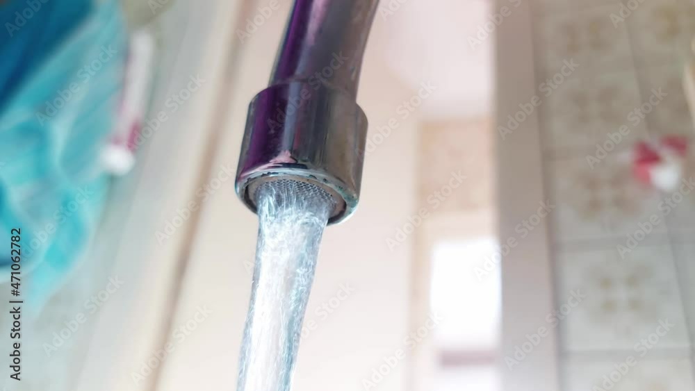Water from the faucet flows into the sink drain. Water consumption, sewerage and plumbing concept Water from the faucet flows into the sink drain. Water consumption, sewerage and plumbing concept