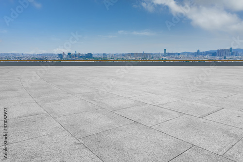 Empty brick floor with city skyline background