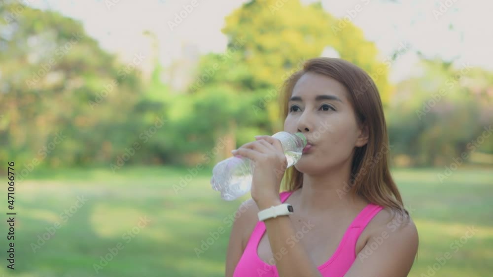 Exercise concept of 4k Resolution. The girl is resting to drink water after exercise that loses sweat. Exercise concept of 4k Resolution. The girl is resting to drink water after exercise that loses sweat.