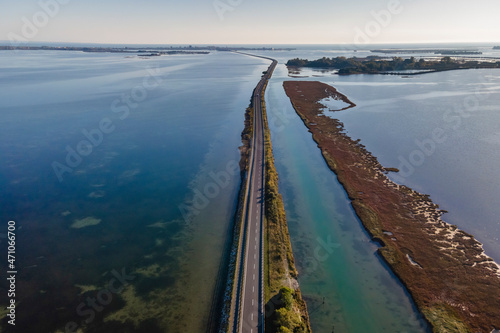 Aerial view of vehicles driving on a beautiful road crossing the lagoon in Grado near Gorizia, Friuli Venezia Giulia, Italy. photo