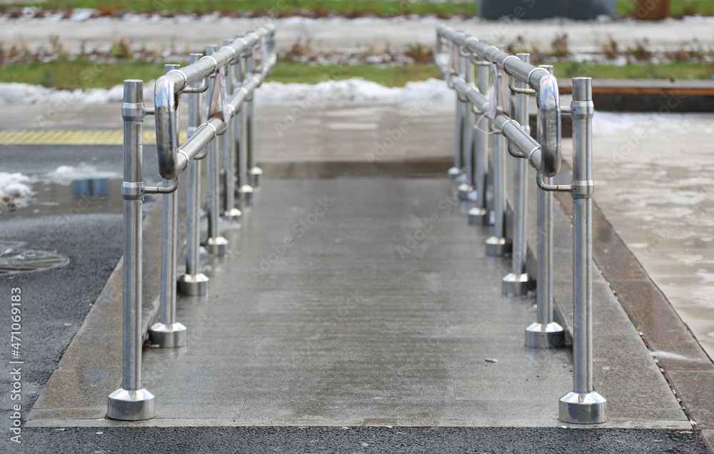 Obraz premium Gentle descent with metal handrails for people with disabilities