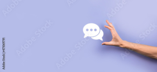 Businessman holding a message icon, bubble talk notification sign in his hands. Chat icon, sms icon, comments icon, speech bubbles © Ivan