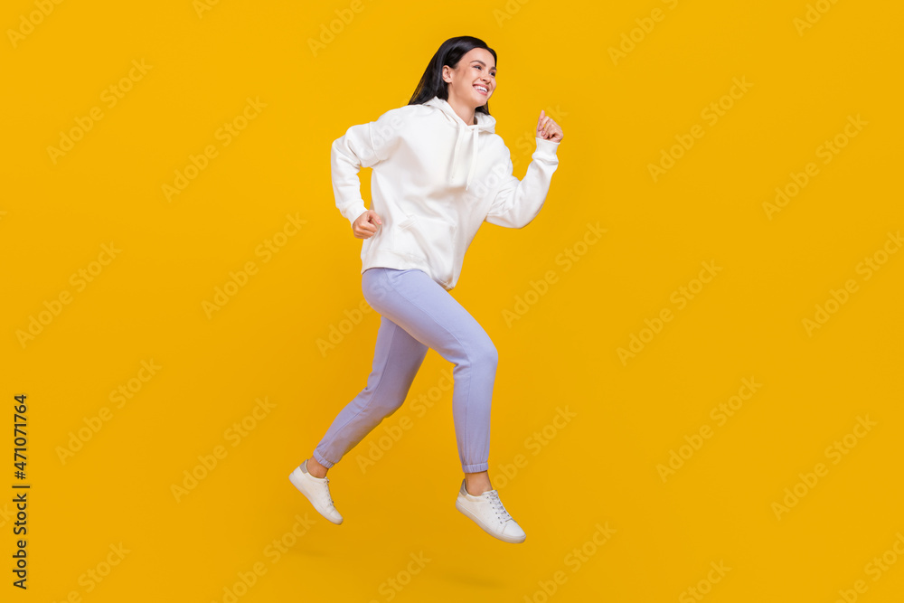 Full length profile side photo of youth lady jump practice sprint race run street style isolated over shine yellow color background