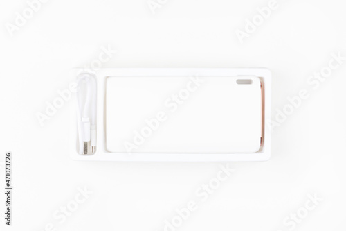 white power bank for charging smartphones and various digital devices on a white background close-up top view