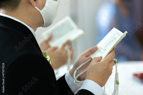 Prayer and holding prayer book and jutsu beads in japanese buddhist nichiren or shinto culture religion. Buddhist wedding ceremony	
