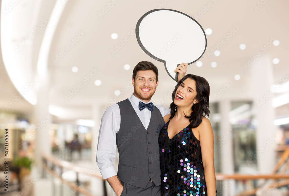 fashion, style and sale concept - happy couple hugging at party and holding blank text bubble banner over shopping mall background fashion, style and sale concept - happy couple hugging at party and holding blank text bubble banner over shopping mall background