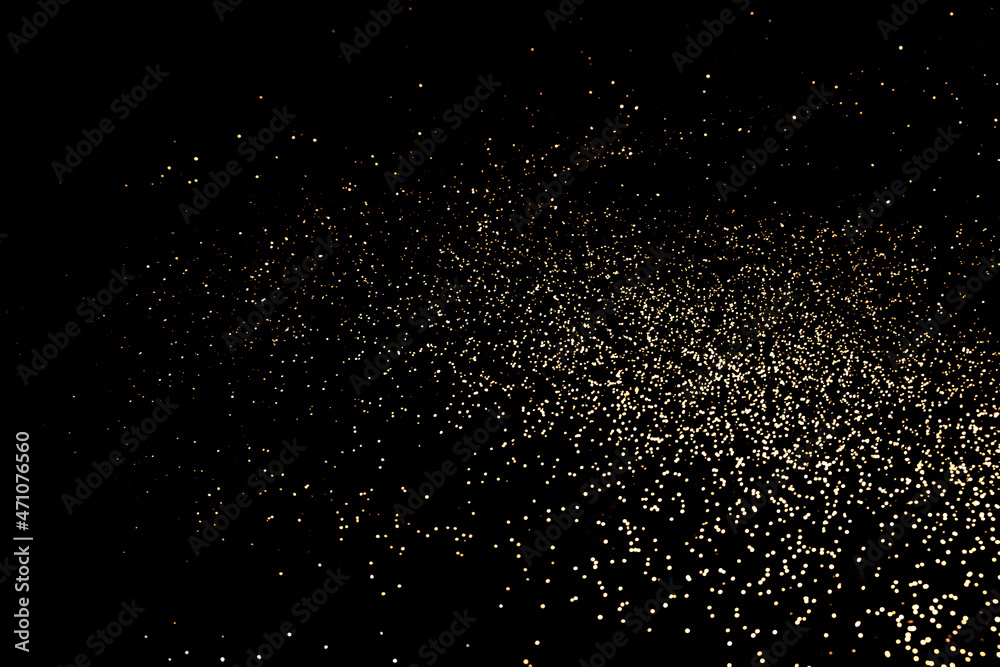 Black festive background. Abstract scattering of gold sparkles on black. Holiday backdrop, selective focus Black festive background. Abstract scattering of gold sparkles on black. Holiday backdrop, selective focus