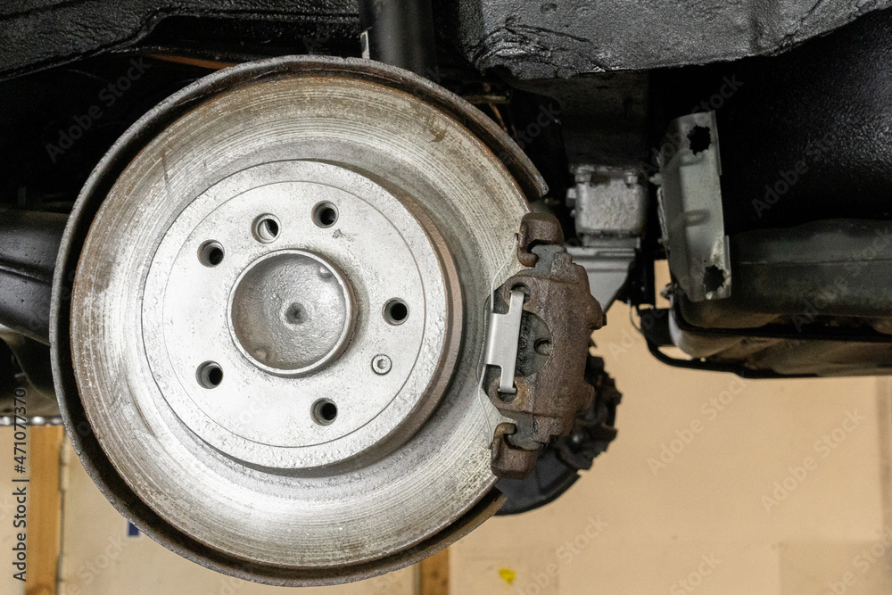 Close-up photo of a brake disc and a car caliper. Auto garage