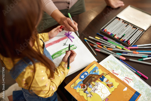 Woman and girl doing colorful drawing at home