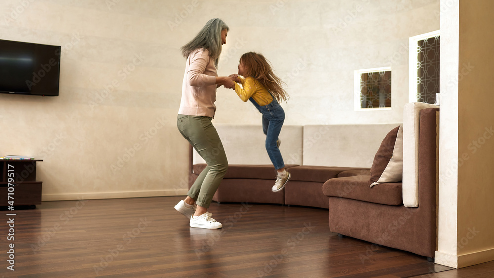 Cheerful aged mother with cute little daughter