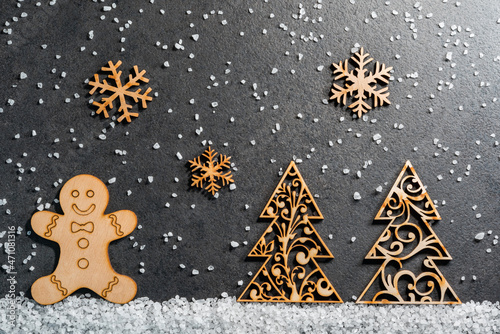Christmas background from wooden figurines of a gingerbread man, a Christmas tree and snowflakes.