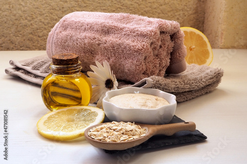 Making a homemade face mask. Ingredients: Oatmeal, almond oil, lemon. Bowls, bottles, spoons, brush, towel. Home skin care concept