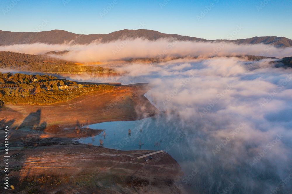 Aerial view of early morning light over a mountain lake covered with fog Aerial view of early morning light over a mountain lake covered with fog