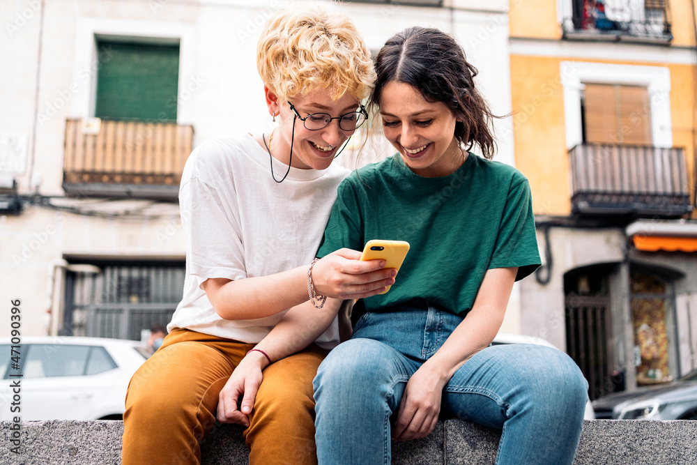 Lesbian couple using smartphone Lesbian couple using smartphone
