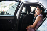 Smart young and beautiful Asian businesswoman getting in or getting out of a car.