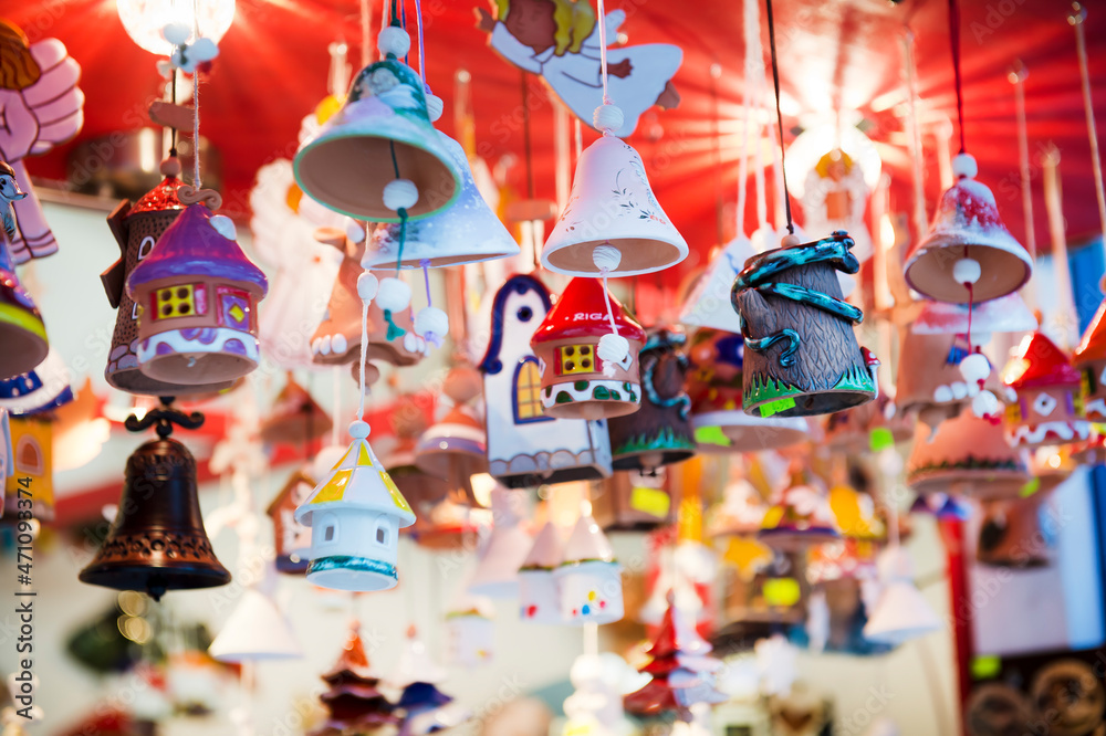 Obraz premium New Year's Christmas decorations, bells, houses, angels, souvenirs at the Christmas market in the shop. Pendants, handmade ceramics. Can be used for websites, brochures, posters, printing and design.