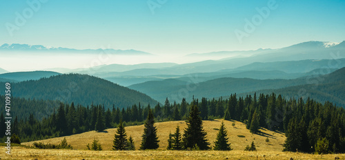 View from the side of Lake Belmeken to the Rila mountains and the peaks of the Pirin mountains in the fog photo