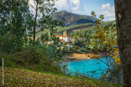 Picturesque village of Dornes in the Zezere river - Portugal. Old church and castle over the river with mountain background photo