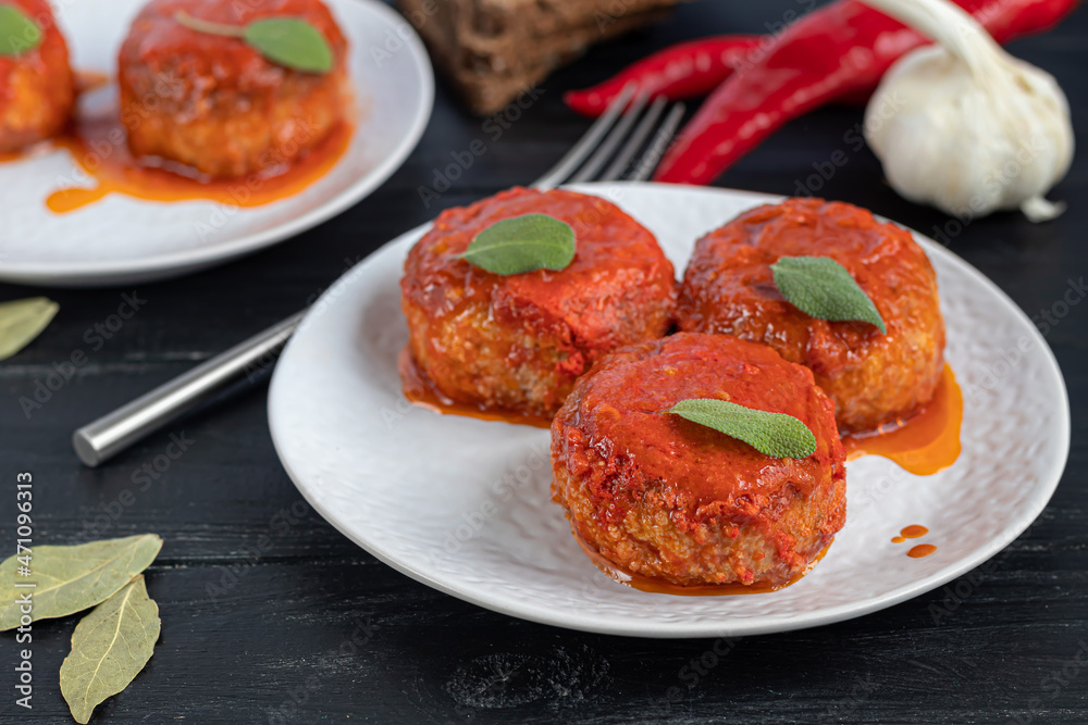 Fish cakes in tomato juice with onions and carrots. Diet. Sauerkraut. On a dark wooden background. Fish cakes in tomato juice with onions and carrots. Diet. Sauerkraut. On a dark wooden background.
